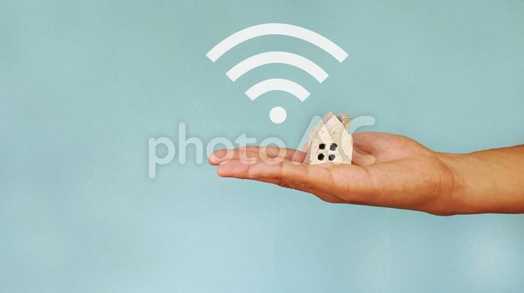家小物を乗せる手とWifiマーク_青背景 家,wifi,wiーfiの写真素材