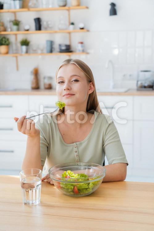 カメラ目線でサラダを食べる女性 女性,人物,座るの写真素材