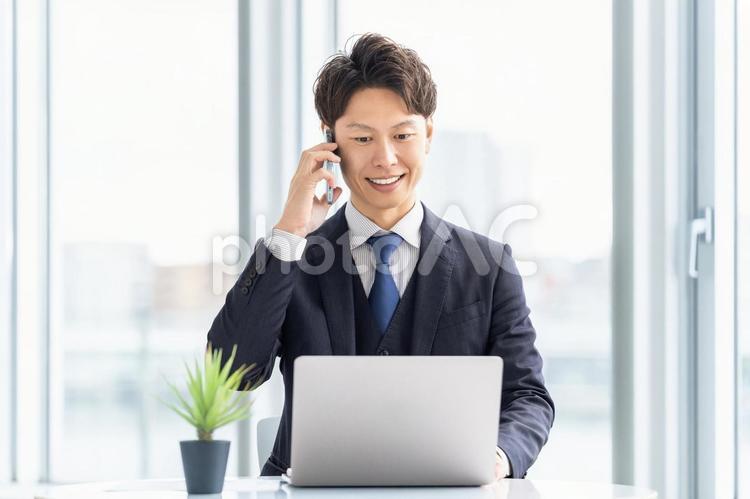 スマホで通話をする笑顔の男性ビジネスマン 男性,ビジネス,スマホの写真素材