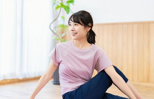 自宅のリビングでストレッチをする女性 自宅のリビングでストレッチをする女性 女性,ストレッチ,柔軟の写真素材