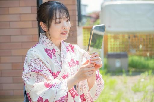 笑顔で鏡を見る浴衣女性 笑顔で鏡を見る浴衣女性 浴衣,和装,女性の写真素材