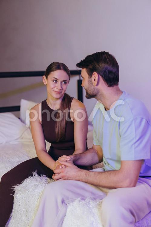 微笑んで手を握るカップル 女性,男性,ヒゲの写真素材