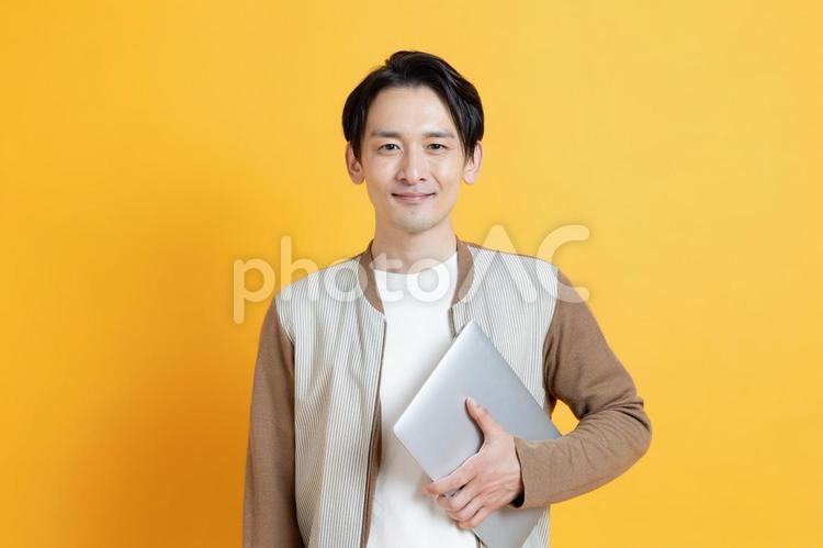パソコンを持つ笑顔の日本人男性 男性,イケメン,夫の写真素材