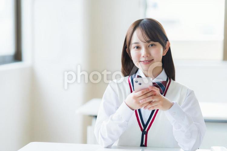 教室で勉強する学生 高校生,スマホ,笑顔の写真素材