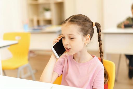学校で携帯で話す女の子 女の子,子ども,人物の写真素材