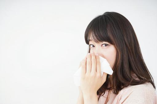 Young woman blowing her nose, pollen, hay fever, dust, JPG