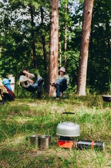 キャンプ用品と人物　縦 ケトル,マグカップ,コンロの写真素材