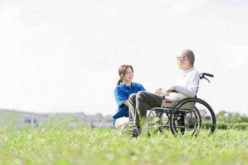 Elderly people and caregivers having a conversation on the lawn, wong tuwa, a kursi rodha, perawat, JPG