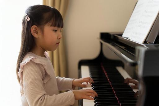 ピアノの練習をする女の子 ピアノの練習をする女の子の写真