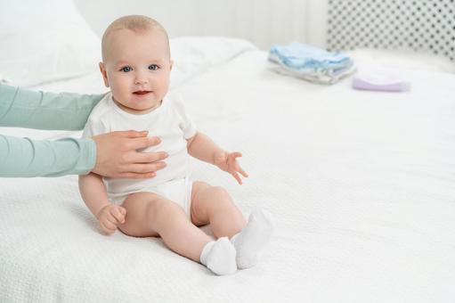 Baby sitting with support and looking at the camera, JPG Baby sitting with support and looking at the camera, JPG
