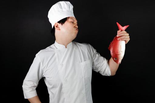鮮魚を持つ料理人の姿 料理人,シェフ,白衣の写真素材