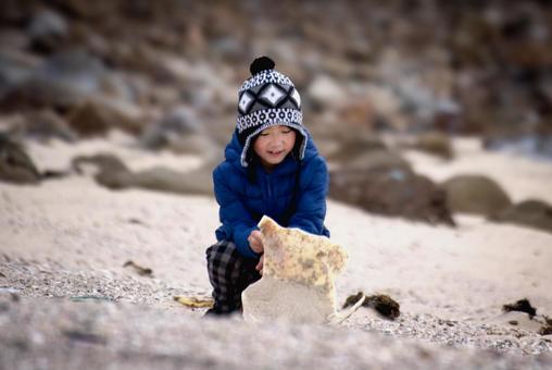 <素材>冬の砂浜で元気に砂遊びをする少年 <素材>冬の砂浜で元気に砂遊びをする少年 子供,砂丘,海の写真素材