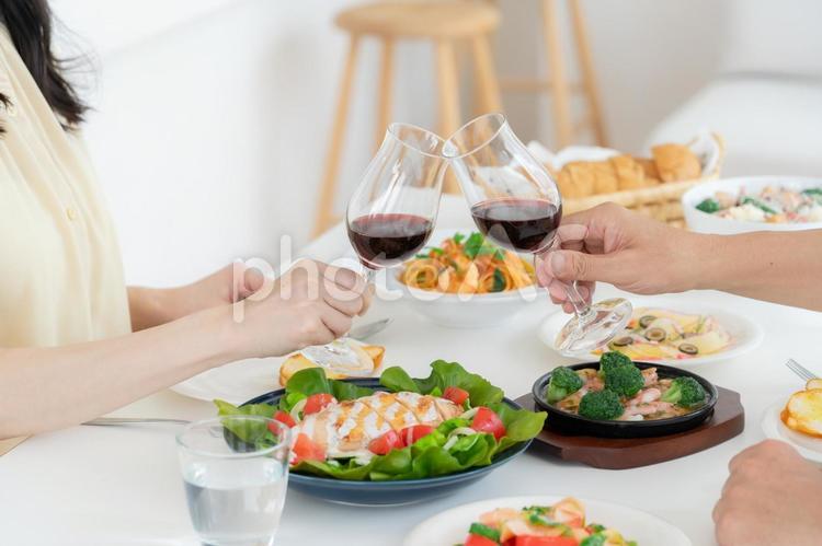 ダイニングで食事をするミドルの夫婦 乾杯,ワイン,食事の写真素材