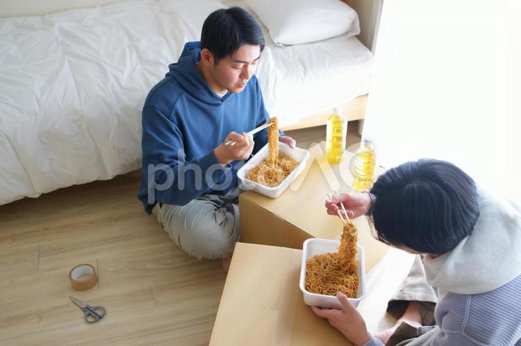 引っ越しの合間にカップ焼きそばを食べる2人の男性 引っ越し,一人暮らし,男性の写真素材