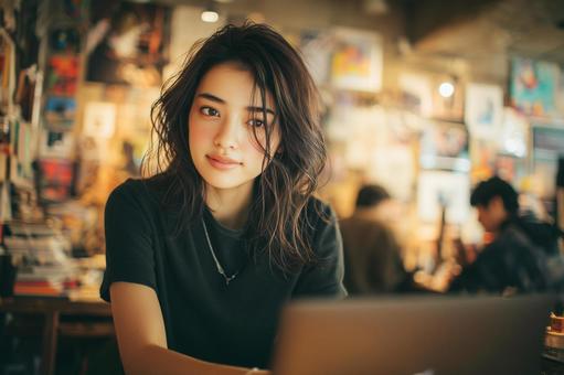カフェでノートパソコンを使用する女性の写真