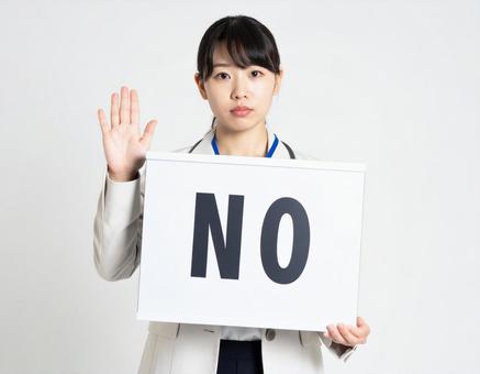 Noと書かれたボードを持つ女性社員 Noと書かれたボードを持つ女性社員の写真