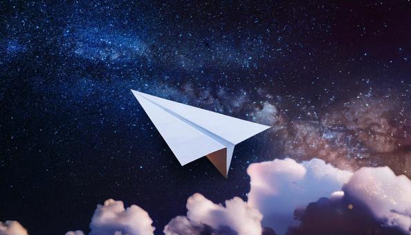 宇宙に向かって飛んでいる紙飛行機 宇宙に向かって飛んでいる紙飛行機の写真