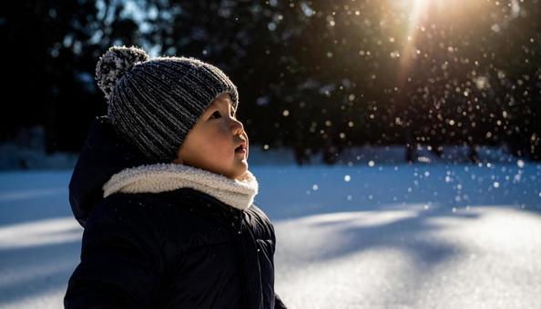 雪を見上げる可愛い子供の写真