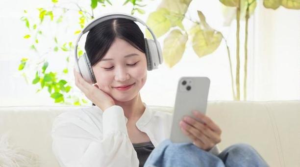 ワイヤレスヘッドフォンで音楽を聞く女性 ワイヤレスヘッドフォンで音楽を聞く女性 女性,ワイヤレス,聴くの写真素材