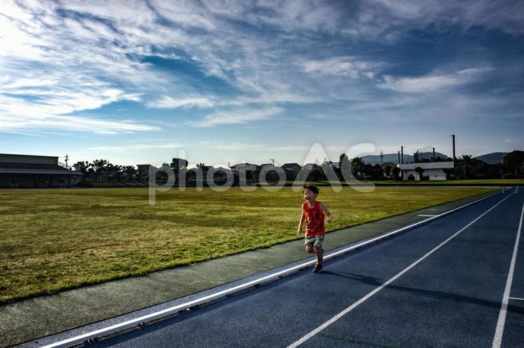 ＜素材＞夕暮れに短距離走の練習をする少年 子供,走る,陸上の写真素材