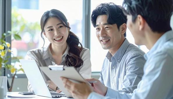 テーブルを囲んで会議するビジネスパーソンの写真