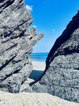 岩の切れ間と青い海の写真