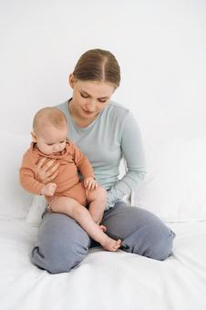 膝の上に座り抱っこされ下向きの親子 膝の上に座り抱っこされ下向きの親子 親子,母子,赤ちゃんの写真素材