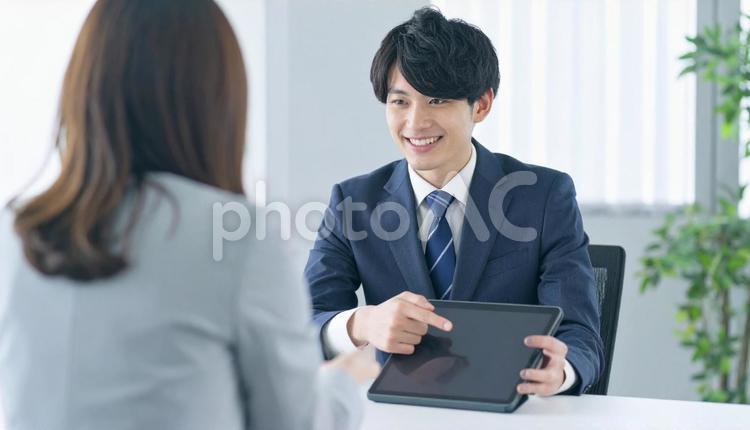 タブレットを使って説明する男性営業マン タブレット,男性営業マン,男性ビジネスマンの写真素材