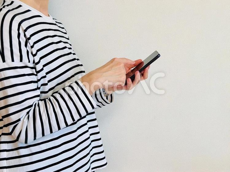 スマホを操作するママ（横向き） スマホ,女性,snsの写真素材