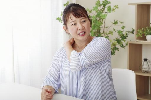 肩こりに悩む中年のアジア人女性の表情 肩こりに悩む中年のアジア人女性の表情 肩こり,肩凝り,肩揉みの写真素材