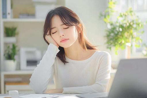 睡眠不足で仕事に集中できない女性 睡眠不足で仕事に集中できない女性の写真