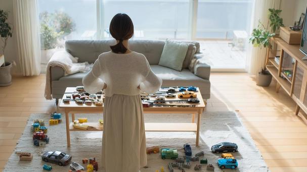 おもちゃで散らかった部屋に怒る母親 おもちゃで散らかった部屋に怒る母親の写真