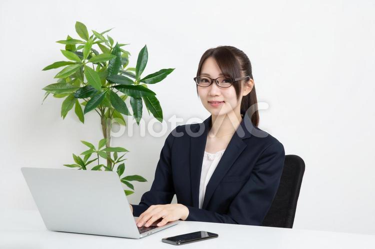 パソコンで仕事をしているメガネをかけたビジネスウーマン（観葉植物あり） ビジネス,パソコン,人物の写真素材