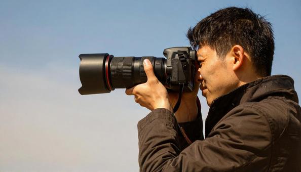 レンズを向ける日本人男性カメラマン レンズを向ける日本人男性カメラマンの写真