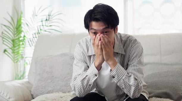 ソファで落ち込むアジア人男性 ソファで落ち込むアジア人男性 男性,落ち込む,ショックの写真素材
