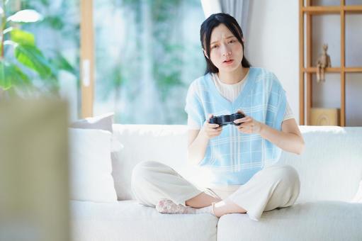 悲しい顔でコントローラーを持つ女性 女性,日本人,悲しいの写真素材