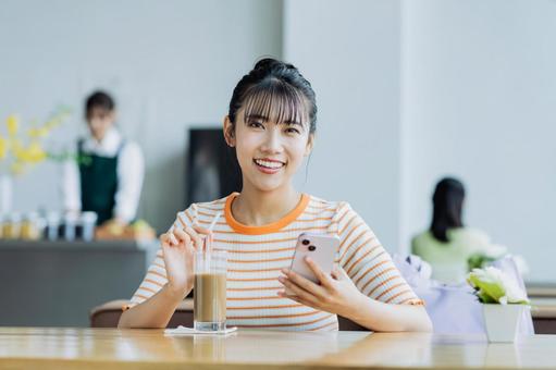 カフェでくつろぐ若い女性 カフェでくつろぐ若い女性 女性,カフェ,笑顔の写真素材