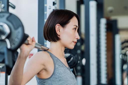 ジムでトレーニングするミドルの女性 ジム,バーベル,女性の写真素材