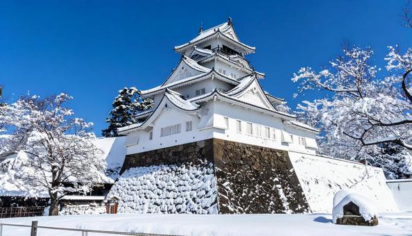 雪化粧した城郭の天守の写真