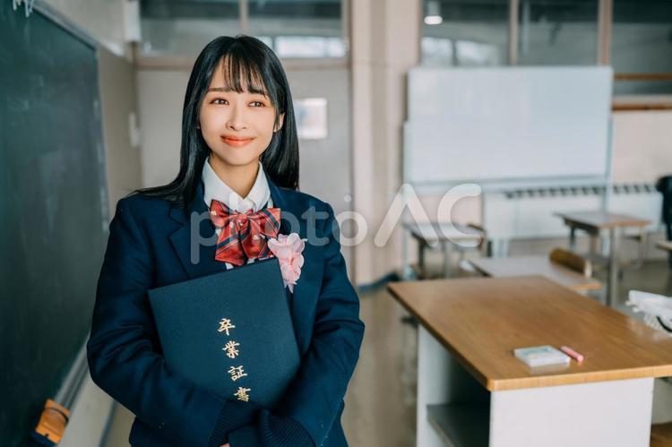 卒業証書を持って嬉しそうに笑う女子高生 女性,女子高,高校生の写真素材