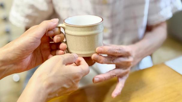 高齢女性に飲物介助する女性の手 高齢女性に飲物介助する女性の手 飲ませる,水分補給,飲み物の写真素材