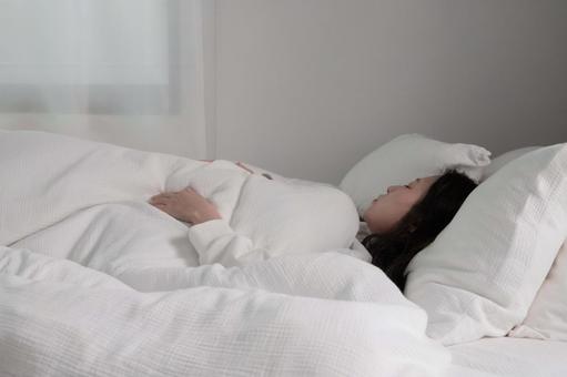 白い布団で眠る女性 白い布団で眠る女性 ベッド,布団,眠るの写真素材