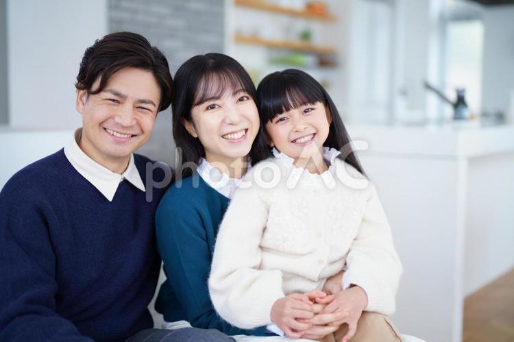 カメラ目線で抱っこして座る家族 家族,女の子,女性の写真素材