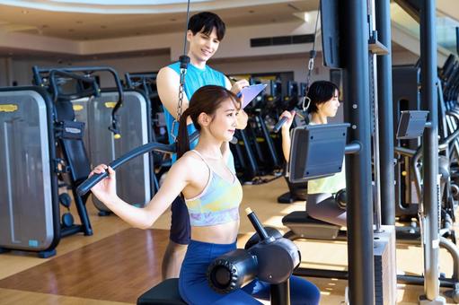 スポーツジムで笑顔の女性とトレーナー エクササイズ,フィットネス,スポーツジムの写真素材