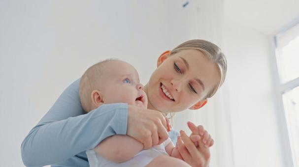 赤ちゃんの手を握り笑う若い女性 赤ちゃんの手を握り笑う若い女性 親子,抱っこ,赤ちゃんの写真素材