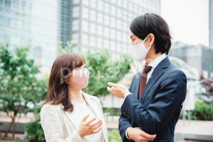 マスク姿のビジネスマン、ビジネスウーマン（話す） マスク,ビジネスマン,飛沫感染の写真素材