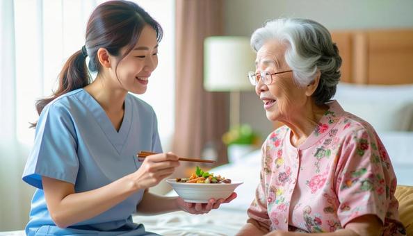 食事介助をする女性介護士と高齢女性 食事介助をする女性介護士と高齢女性の写真