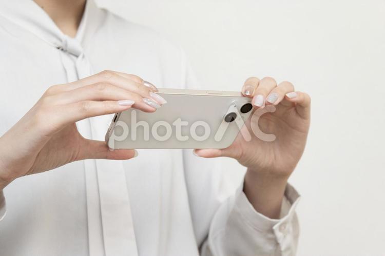 スマートフォンで撮影をする女性 スマホ,スマートフォン,ビジネスの写真素材