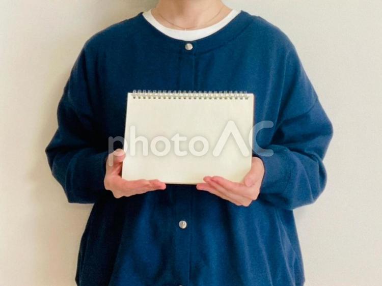 白紙のノートを持つ女性 スケッチブック,女性,案内の写真素材