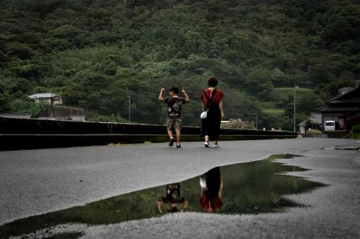 <素材>雨上がりの道を散歩する親子 <素材>雨上がりの道を散歩する親子 家族,子供,女性の写真素材